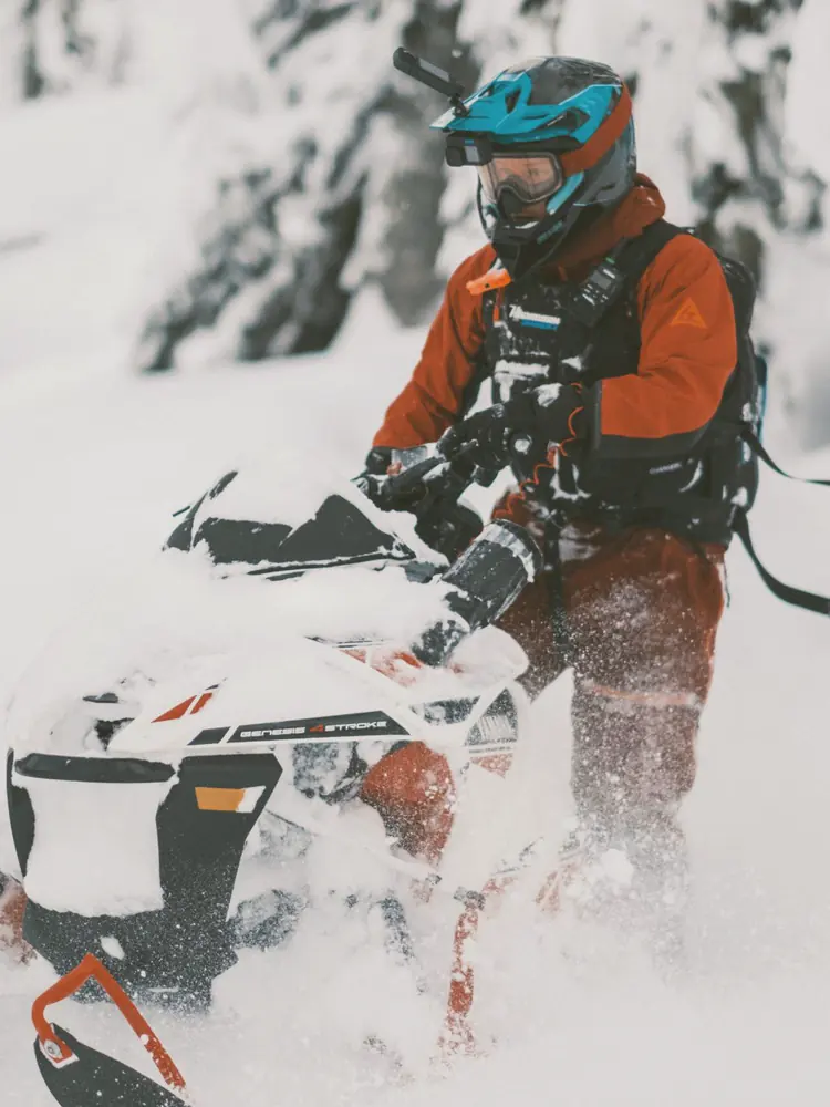 Jani riding through deep powder between snowy trees